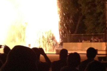 Hand held Tezutsu fireworks dwarf the participant.