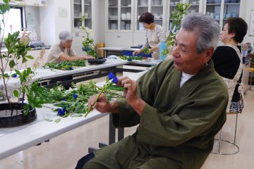 L'Ikebana sensei conseillant un élève sur la meilleure manière de présenter les fleurs