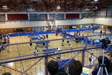 Table tennis matches in the springtime, seen from the parent-filled balcony.