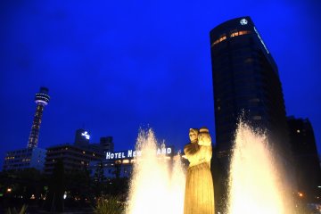Goddess of Water standing with Hotel New Grand at her back