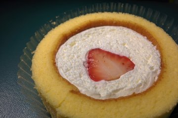 Premium Roll Cake dengan potongan stroberi di tengahnya