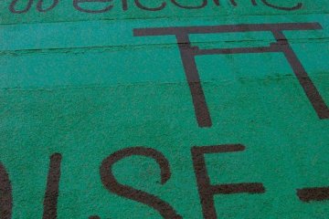 The outside of the building, which used to be a traditional style inn, has been repainted green with some artistic flare.