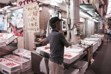 A vendor shows off his goods to passing trade