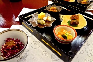 Vous vous verrez tout d'abord servir différentes sortes d'amuse-bouches dans des petits plats, tous disposés sur des plateaux en ébène laqué. Vous pourrez contempler tout à la fois la beauté des couleurs, formes et les saveurs des mets