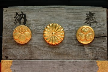 Three different crests on the offering box at the shrine