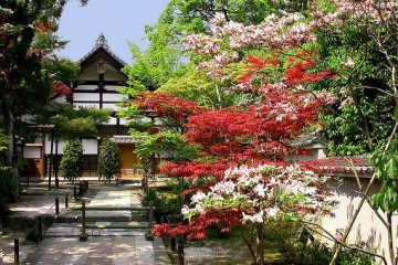 A smaller building on the temple grounds, surrounded by flowers.