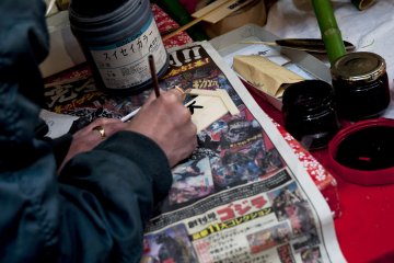 Penjual yang sedang mempersiapkan jimat keberuntungan