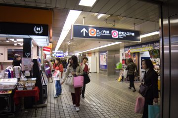 Continuez à les suivre jusqu'à ce que vous descendiez des escaliers et vous vous retrouviez dans une zone avec des stands