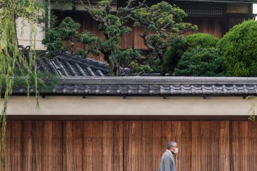 An elderly gentleman makes his way by some of the quarter's architecture