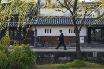 A business man walks along the quarter's canal