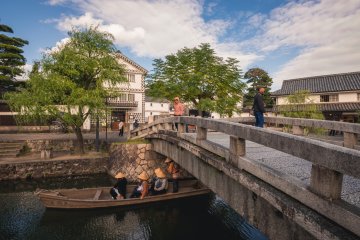 A canal boat passes beneath the central bridge