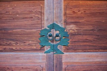Artisticly stunning door ornamention surrounding the ring pulls
