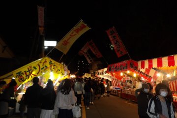 The streets surrounding the shrine are brightly lit and full of food