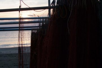 <p>There is a lot of fishing nets, boats and gear on the beach</p>