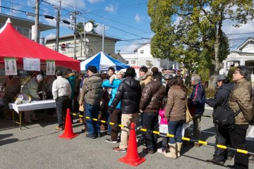 People line up to enjoy roasted boar