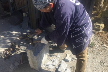 Craftsman showing how to make the stone lanterns