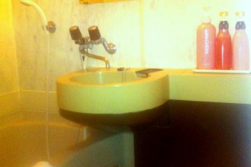 Small but practial bathroom with combined bath and shower and Shisedo Bath products at Hotel Rasso just 10 min walk from Kokusai dori