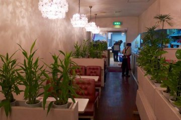 Swanky chandeliers and red upholstered chairs give the interior a retro feel