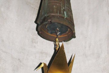 A bell inside the memorial with a crane