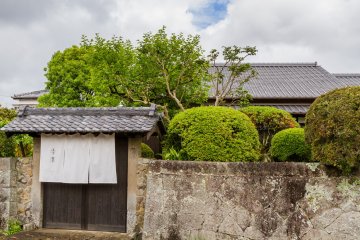 The stone wall and front gate of Katsume seclude the home and garden