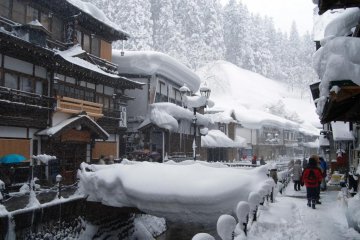 Some restaurants and souvenir shops at Ginzan Onsen invite visitors to step in and warm up their cold feet