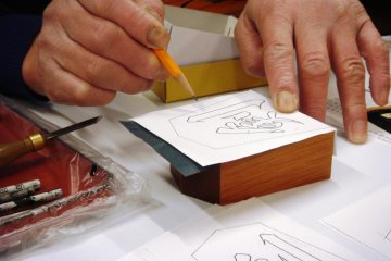 Trace the lines of the kanji character by pencil to copy it onto the shogi piece - Tendo Town, home of Japanese chess