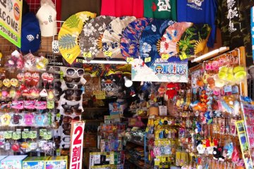 Shisa Dolls T Shirts and Okinawan food  for sale at the souvenir shop next to Shuri Castle its bright colors reminescent of a Taipei or Mongkok Market