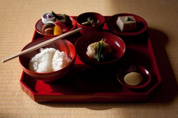 The set meal consists of rice, soup, vegetables, beans and an array of bean curd variations—all served on a red lacquer tray