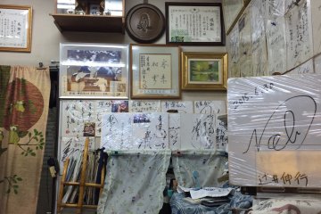 Dinding kedai yang dihiasai dengan tanda tangan para pengunjung