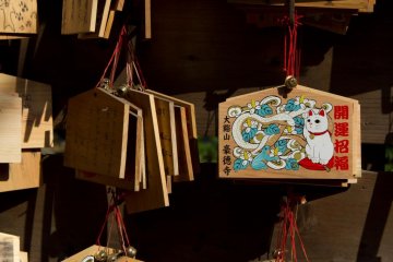 Wooden wishing plaques, called Ema, certainly feature the cat too