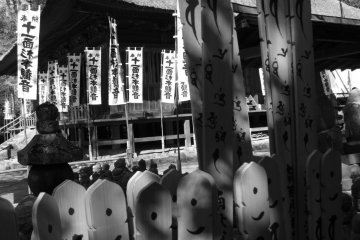 A collection of Buddhist statues, with the temple behind them