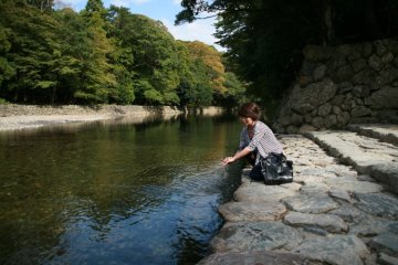 <p>Washing hands for purification in the cool clear river</p>