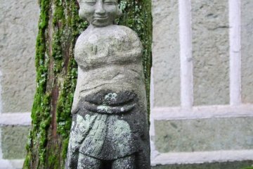 Statue, tree, house - this shrine is tucked in amongst a lot of houses