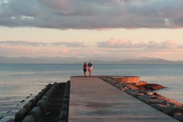 Strolling along a breakwater at sunset.