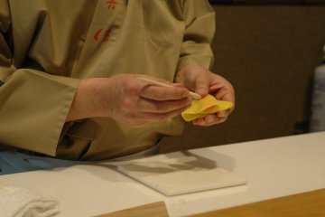 Menggunakan sebuah alat untuk membuat kudapan ini agar tampak seperti seekor kupu-kupu