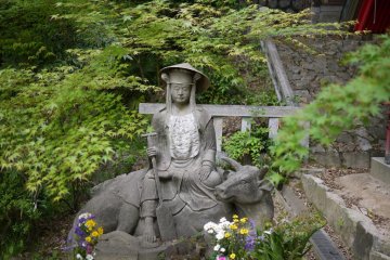 Interesting statue of a man riding an Ox next to Inari Jinja.