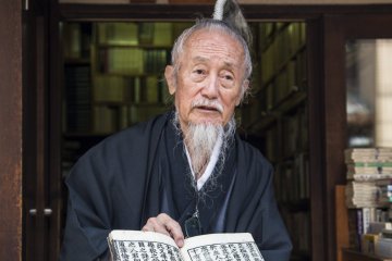 Okada showing tour members a hundred-year-old book from a small bookshop