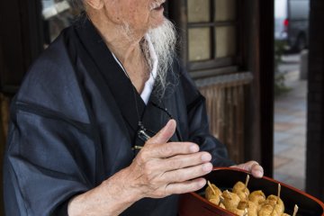 Okada stops by a shop that has been selling inari for more than 50 years