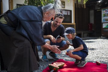 Okada invites tour members to have some of the fruit he cut up