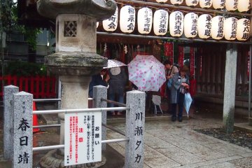 People stopping by the chouzuya (purification pavilion) to do the cleansing ritual.