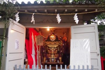 Mikoshi (palanquin) that is to be carried in the procession. On the left door is a sign posted informing visitors that there would be no procession this year. On the right is information on the shrine god (in Japanese).