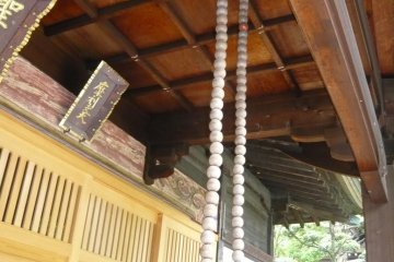 Large prayer beads hang from the roof. Turning them brings devotees merit.