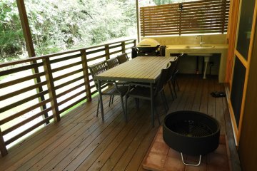 The covered back deck is ready for grilling and relaxing by the fire