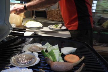 A dinner of seafood, sausages, chicken, steak, and vegetables has something for everyone