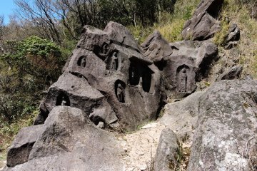 Rock carved with statues at the far end of the pond