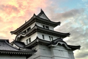 The setting sun catching the clouds over the castle