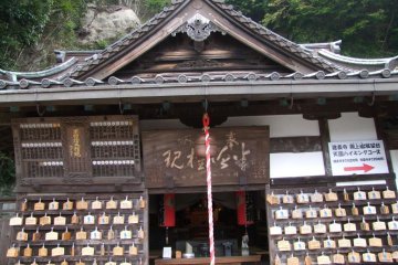 <p>A small, simple shrine with an arrow pointing towards the hiking course</p>