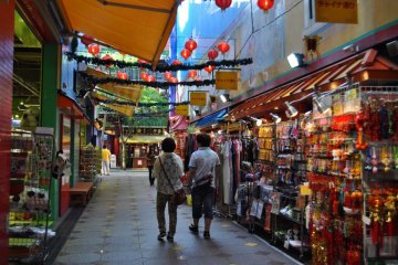 A souvenir shop with red lanterns hanging overhead at dusk