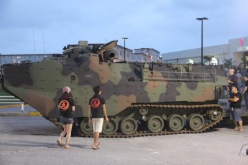 Visitors look at a static display of an advanced amphibious assualt vehicle