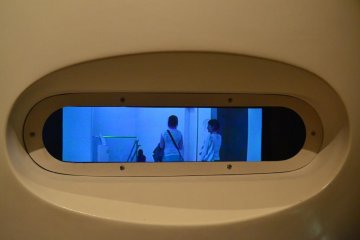 The camera inside this exhibit records the movements of passers by at high speed. This thin and wide blue LCD is able to replay the recorded movements several times over in many styles.